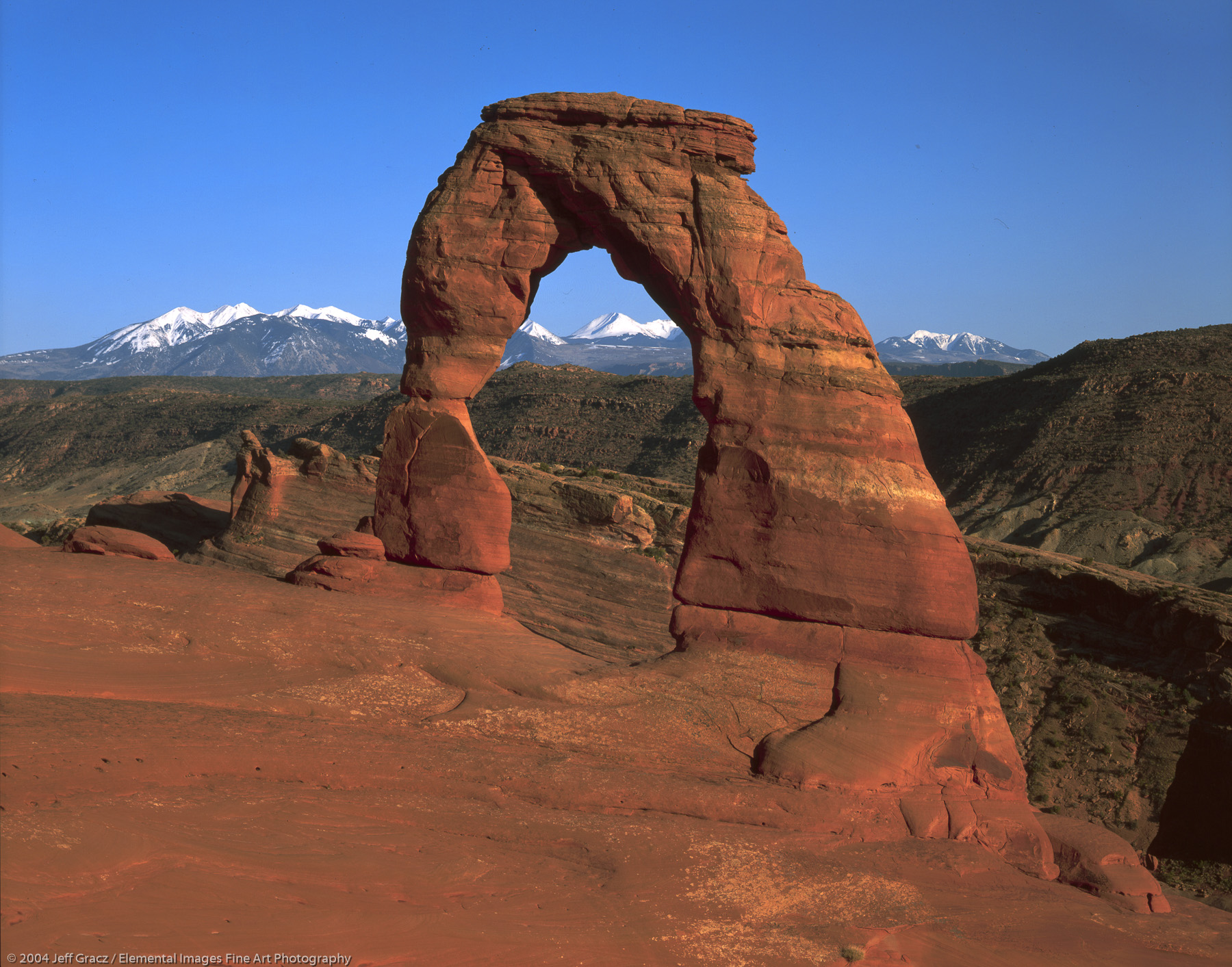 Delicate Arch with distant La Sal Mtns | Arches National Park | UT | USA - © © 2004 Jeff Gracz / Elemental Images Fine Art Photography - All Rights Reserved Worldwide